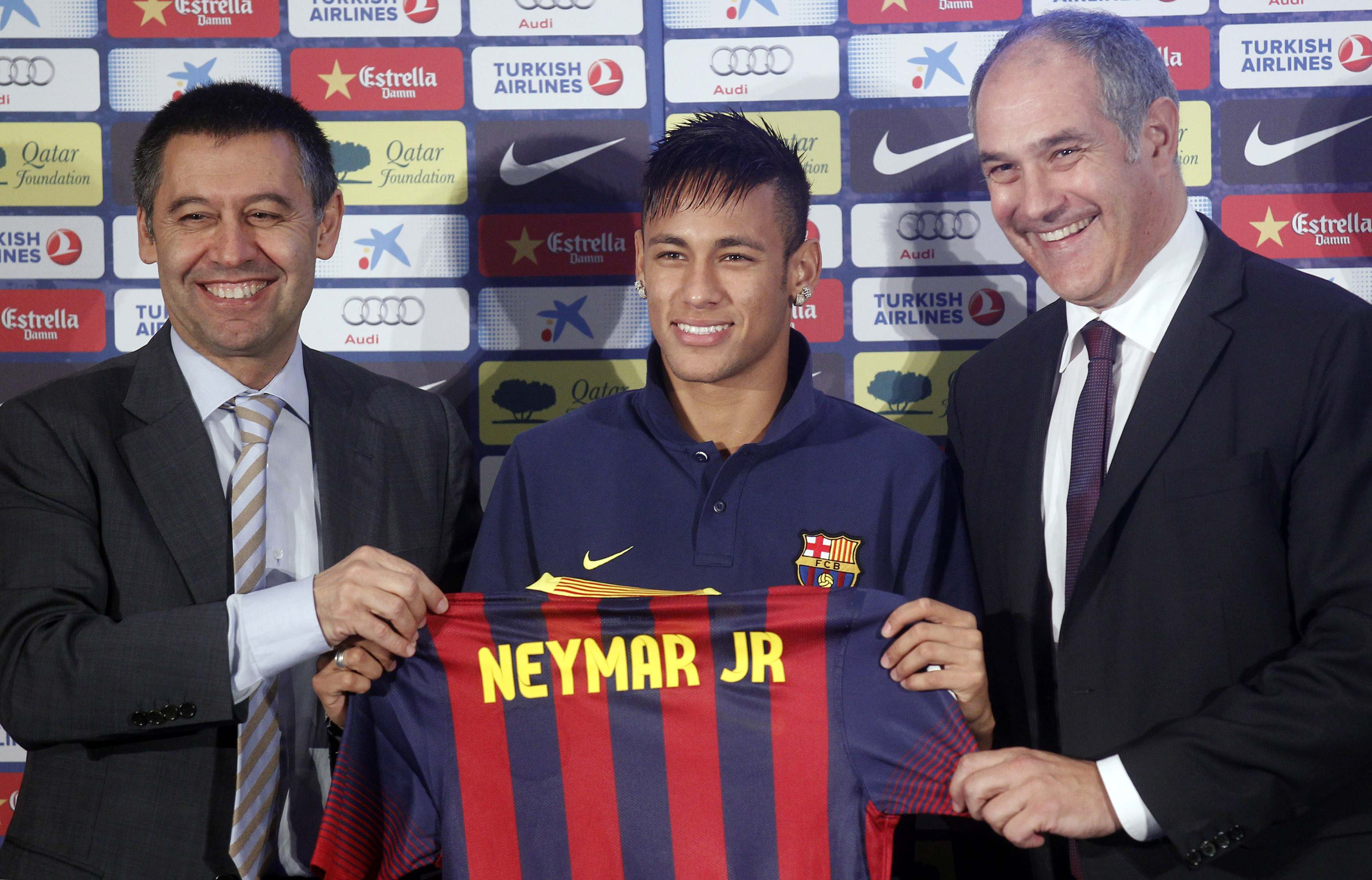 Neymar poses with his new jersey next to sports director Andoni Zubizarreta and vice-president Ferran Bartomeu after signing a five-year contract in Barcelona