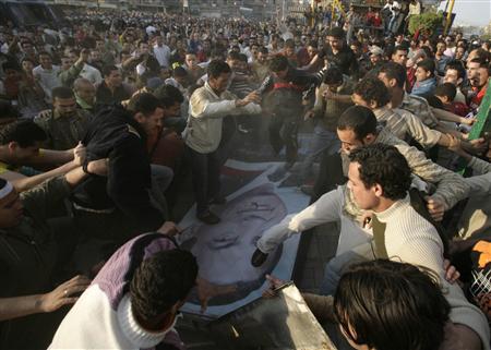 File photo of protesters walking over a picture of Egyptian President Hosni Mubarak in the Nile Delta textile town of Mahalla el-Kubra