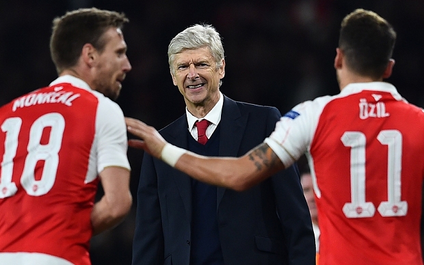 Arsenal's French manager Arsene Wenger (C) watches as Arsenal's German midfielder Mesut Ozil (R) celebrates scoring his team's second goal with teamamte Arsenal's Spanish defender Nacho Monreal during the UEFA Champions League football match between Arsenal and Bayern Munich at the Emirates Stadium in London, on October 20, 2015. Arsenal won the match 2-0. AFP PHOTO / BEN STANSALLBEN STANSALL/AFP/Getty Images