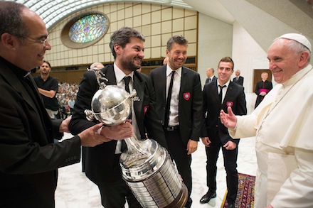 Pope Francis receives the Copa Libertadores trophy from representatives of Argentine soccer team San Lorenzo during his weekly audience in Paul VI hall at the Vatican Aug. 20. (CNS photo/L'Osservatore Romano via Reuters) See POPE-AUDIENCE Aug. 20, 2014.